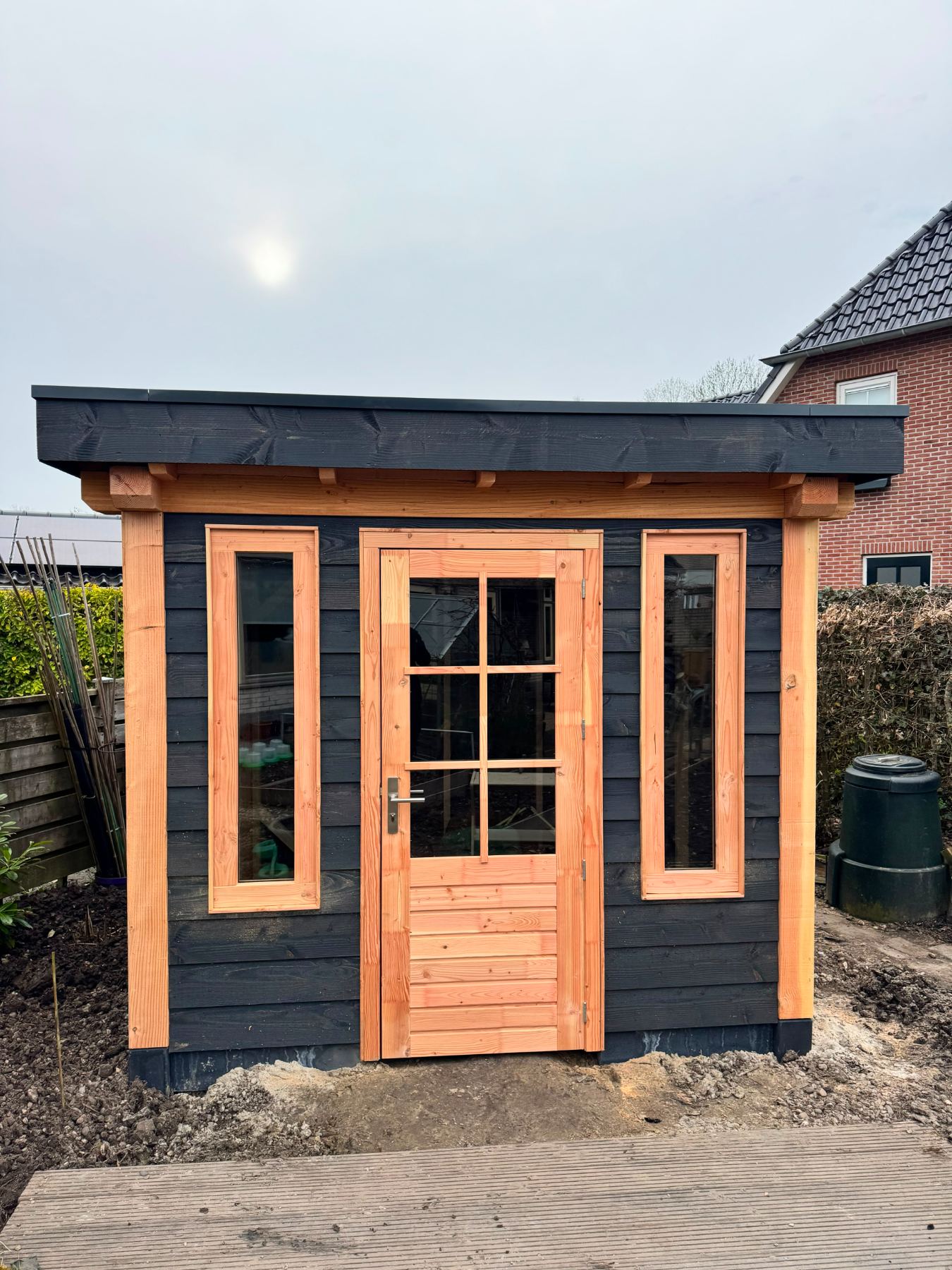 Berging met zwarte wandbekleding, douglas deur en twee smalle ramen